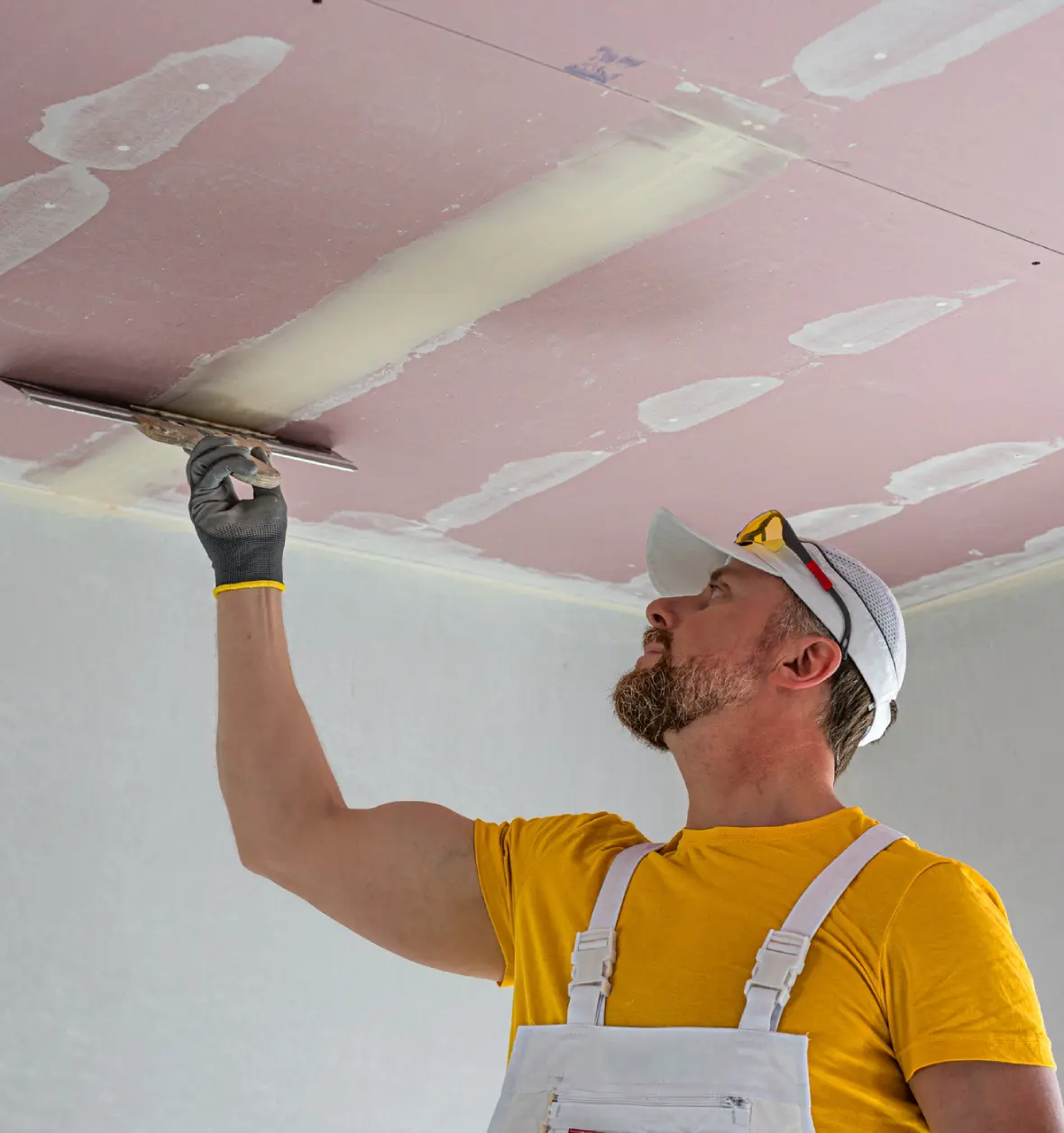Group 8 (8) (6) Man plastering a ceiling with a trowel.
